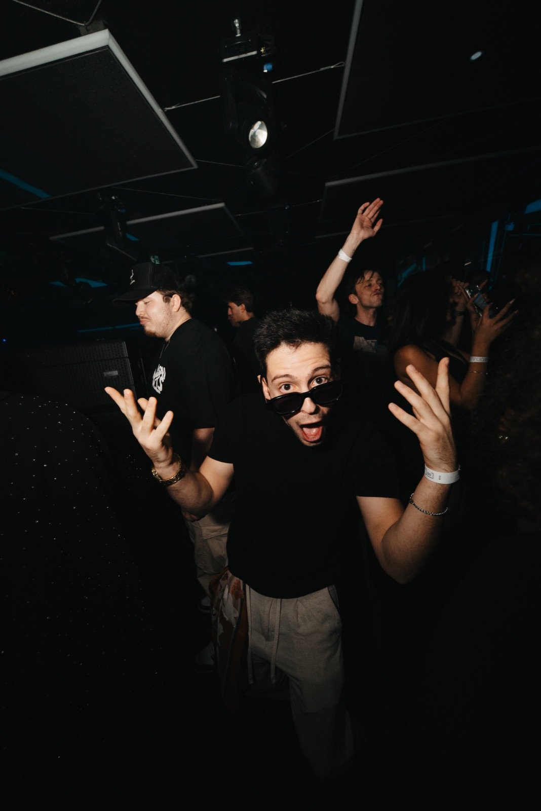 TALMOR hyping up the room, sunglasses on and hands up