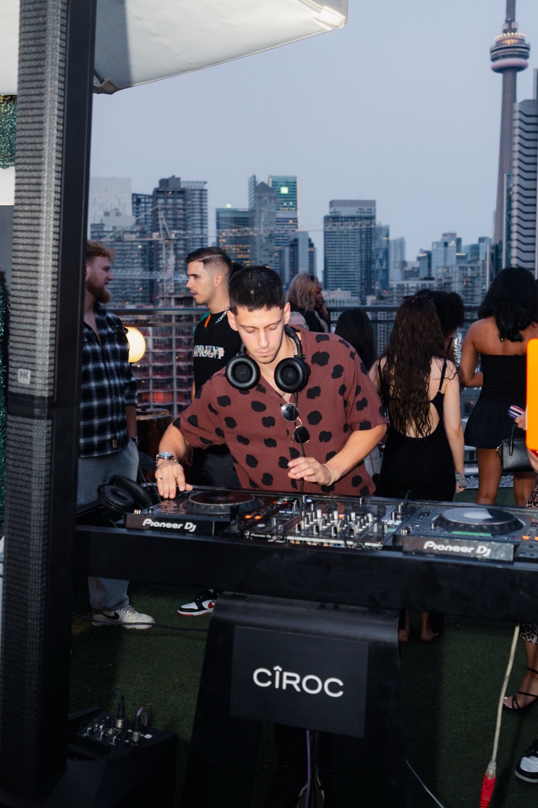 TALMOR focused at the decks at Lavelle rooftop, CN Tower behind him